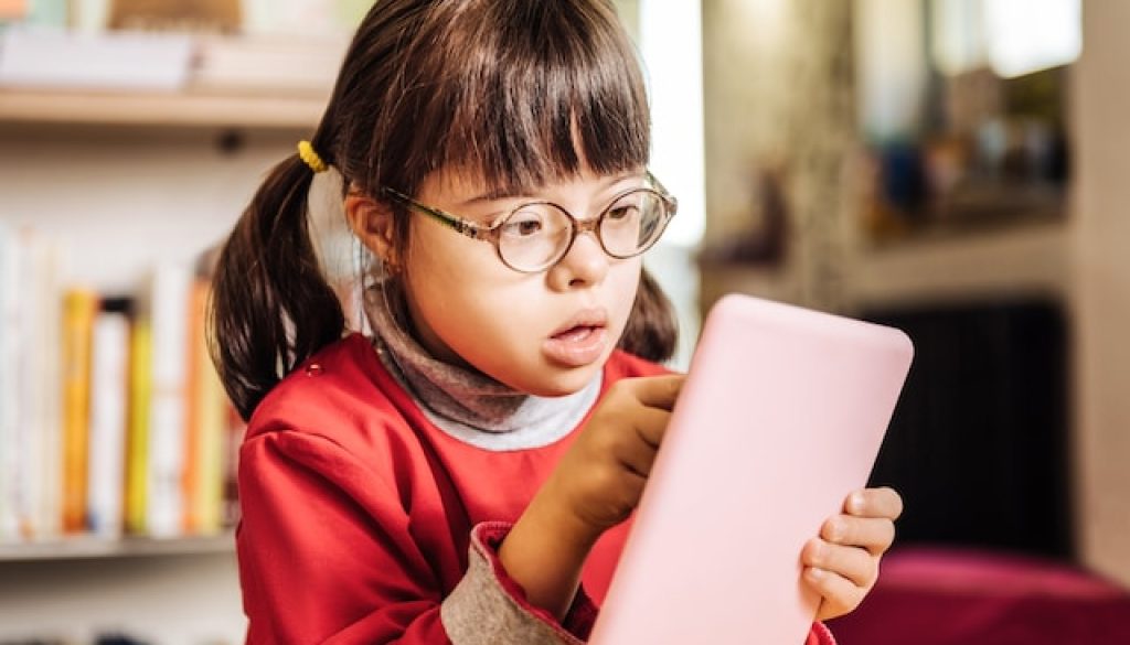 Child with Down Syndrome playing on phone