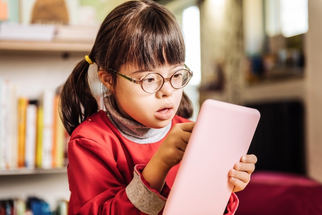 Child with Down Syndrome playing on phone