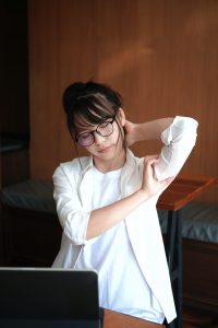 teacher stretching at a computer