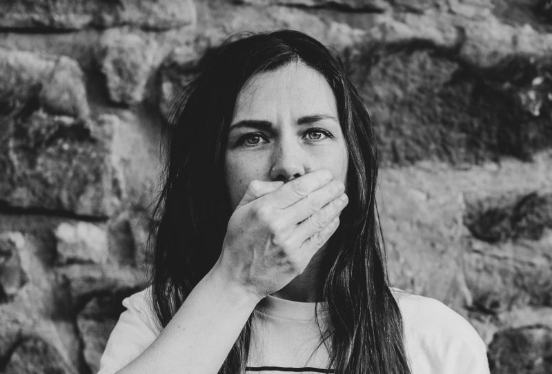 woman covering mouth with hand